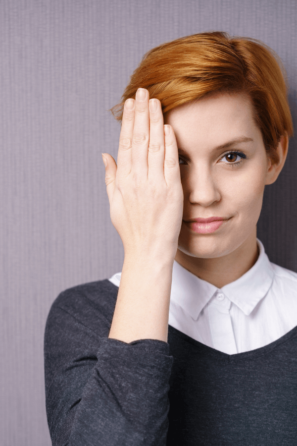 Mulher cobrindo um olho com a mão, simbolizando curiosidade e inconformismo como motores para o crescimento profissional com a GrowPath