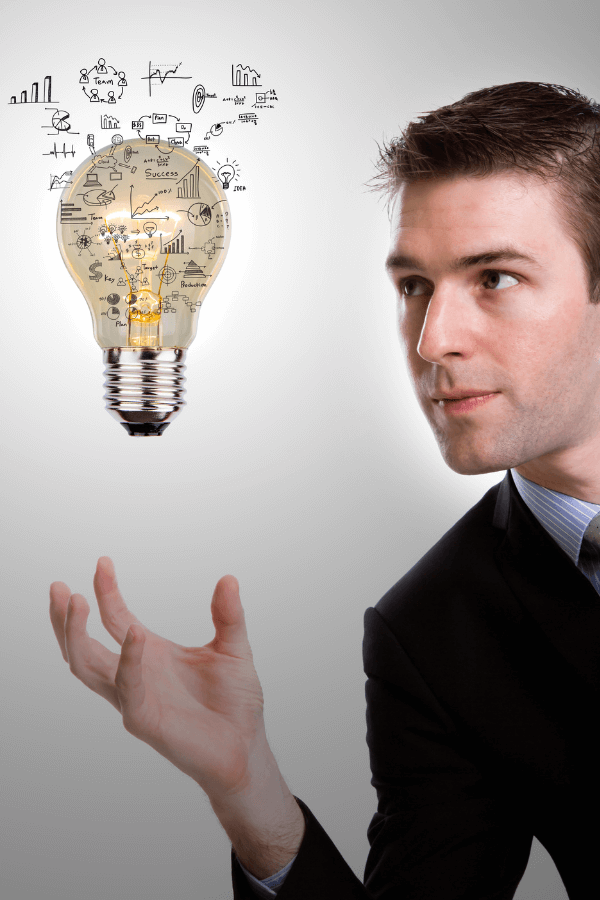 Executivo observando lâmpada com desenhos de gráficos e ideias, representando inovação e simplificação de processos pela GrowPath
