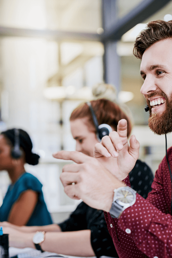 Profissionais de atendimento ao cliente sorrindo e interagindo com entusiasmo, representando o valor da GrowPath de obsessão pelo cliente